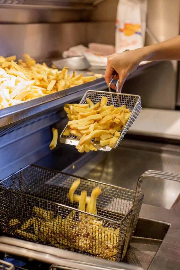 Chip shop worker frying chips